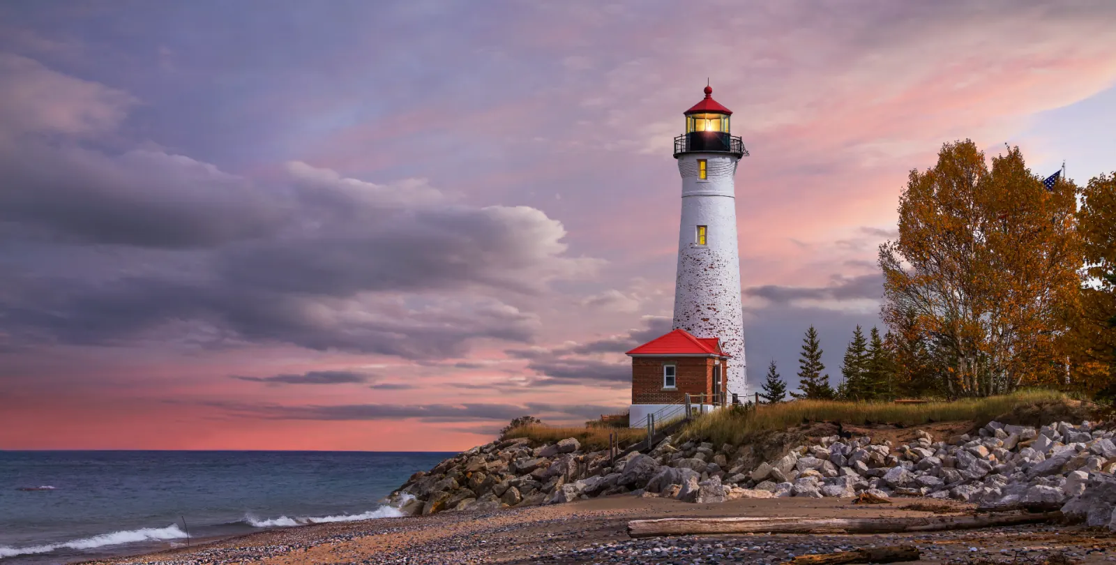 Crisp Point Lighthouse on Lake Superior shoreline at sunset in autumn — Michigan